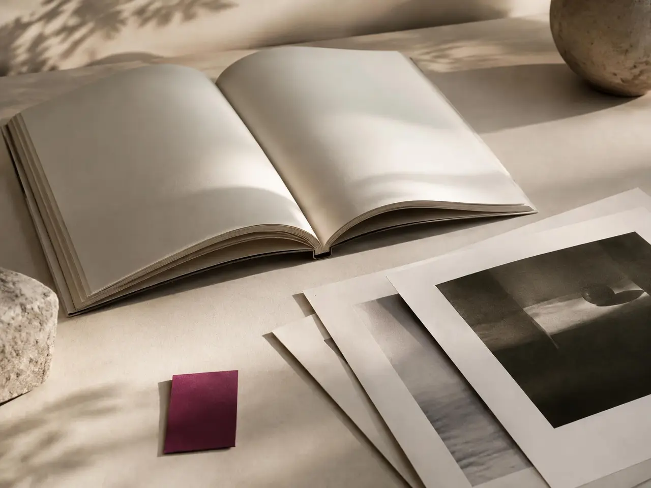 Open book with blank pages and loose photographic prints